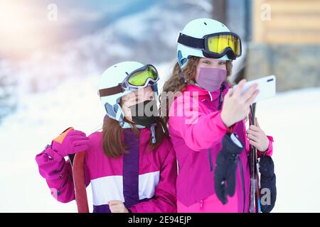 adolescents amis prenant le selfie dans des masques covid sur le ski pente Banque D'Images