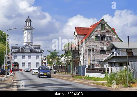 Tour d'horloge en bois blanc du bâtiment du Ministère des Finances et maisons coloniales dans le centre-ville de Paramaribo, Suriname / Surinam Banque D'Images