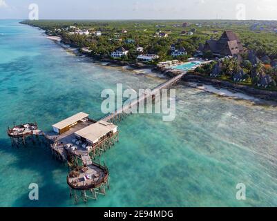 Côte nord de Zanzibar à Nungwi avec phare et toit de chaume Restaurant sur les piliers au-dessus de l'océan Banque D'Images