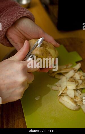 Femme épluchant les pommes de terre en gros plan. Royaume-Uni Banque D'Images