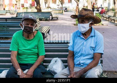 Deux hommes âgés portant des masques protecteurs dans le parc Leoncio Vidal. C'est le moment de la pandémie de Covid-19. Santa Clara, Cuba Banque D'Images