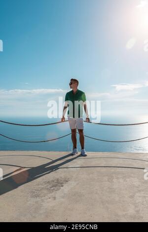 Un homme heureux dans une chemise verte sur fond de mer. Banque D'Images