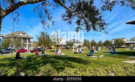 Orlando, FL USA - 30 janvier 2021: Personnes de tous âges faisant du yoga dans un parc de quartier le matin ensoleillé. Banque D'Images