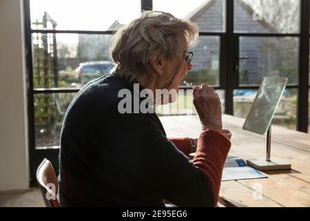 Test à domicile du coronavirus effectué par une femme plus âgée à la maison. Banque D'Images