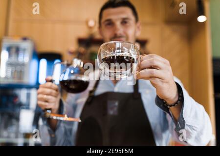 Double verre tasse avec café dans le café. Le barista vous donne une tasse de café. Préparation alternative du café à l'aide de l'appareil Syphon. Banque D'Images