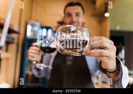 Double verre tasse avec café dans le café. Le barista vous donne une tasse de café. Préparation alternative du café à l'aide de l'appareil Syphon. Banque D'Images