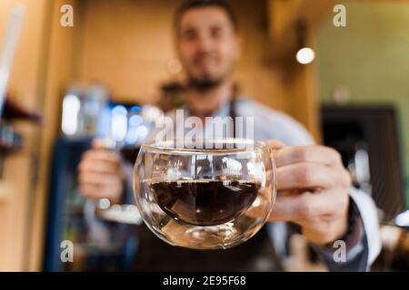 Double verre en gros plan avec café dans le café. Le barista vous donne une tasse de café. Préparation alternative du café à l'aide de l'appareil Syphon. Banque D'Images