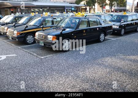 HIROSHIMA, JAPON - FÉVRIER 2019 : une rangée de Toyota Comfort taxis à Hiroshima, Japon. Banque D'Images