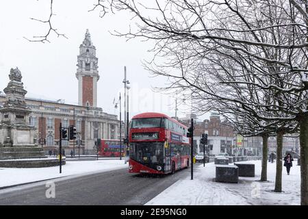 Un bus passe le long de la route EFFRA pendant la neige abondante avec l'hôtel de ville de Lambeth en arrière-plan, Brixton, Londres, 24 janvier 2021 Banque D'Images