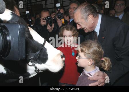 Le président français Jacques Chirac regarde une vache avec des enfants lors de l'ouverture officielle du salon agricole international 2006 qui s'est tenu à Paris-Expo, le 25 février 2006. Photo de Christophe Guibbbaud/ABACAPRESS.COM Banque D'Images