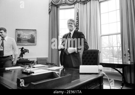 Le président américain Jimmy carter debout derrière son bureau dans le Bureau ovale de la Maison Blanche, Washington, D.C., États-Unis, Marion S. Trikosko, 2 février 1977 Banque D'Images