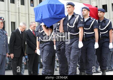 Les soldats libanais portent le cercueil du Français Michel Seurat enveloppé dans le drapeau national de son pays, comme Bernard Emie (à gauche), ambassadeur français au Liban, se met en hommage lors d'une cérémonie de passation de pouvoir à Beyrouth, le 7 mars 2006. Le corps de Seurat, qui a été enlevé il y a plus de 20 ans dans le sud de Beyrouth, a été retrouvé en octobre dernier dans la capitale libanaise, identifié par analyse de l'ADN, et renvoyé mardi en France à bord d'un avion présidentiel français. Seurat, un chercheur enlevé le 22 mai 1985, a été annoncé comme mort un an plus tard dans une déclaration du groupe militant Jihad islamique, qui a dit cela Banque D'Images