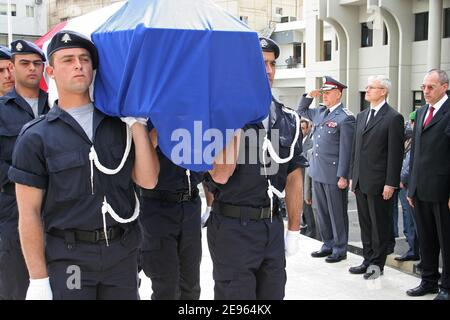 Les soldats libanais portent le cercueil du Français Michel Seurat enveloppé dans le drapeau national de son pays, alors que Bernard Emie, ambassadeur français au Liban (deuxième de droite), rend hommage lors d'une cérémonie de passation de pouvoir à Beyrouth, le 7 mars 2006. Le corps de Seurat, qui a été enlevé il y a plus de 20 ans dans le sud de Beyrouth, a été retrouvé en octobre dernier dans la capitale libanaise, identifié par analyse de l'ADN, et renvoyé mardi en France à bord d'un avion présidentiel français. Seurat, un chercheur enlevé le 22 mai 1985, a été annoncé comme mort un an plus tard dans une déclaration du groupe militant Jihad islamique, Whi Banque D'Images