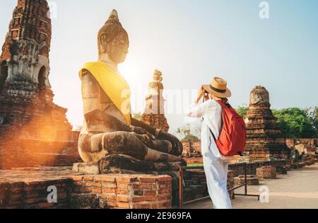Voyageur seule femme avec un sac à dos prenant une photo de Statue de Bouddha assise au Wat Ratchaburana ou au Wat Ratburana bouddhiste temple dans l'Ayutthaya Histo Banque D'Images