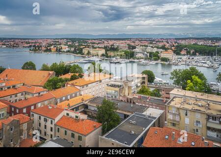 Vue sur les toits de tuiles orange et le paysage urbain de Zadar. Baie ou marina avec yachts amarrés et bateaux, Croatie Banque D'Images