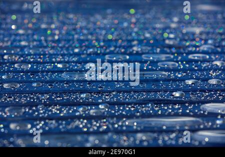 magnifiques gouttes d'eau scintillantes sur des lamelles de table sombres, motif abstrait Banque D'Images