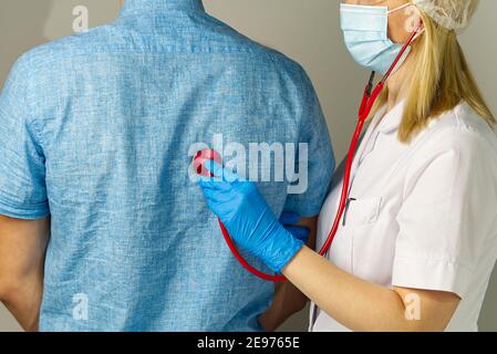 garçon chez le médecin de famille. zone pulmonaire examinée avec stéthoscope. Le pédiatre vérifie la santé, écoute l'enfant avec un stéthoscope. Banque D'Images