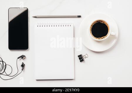 Bloc-notes vierge pour la liste des tâches ou les objectifs café tasse fournitures de bureau papeterie sur fond clair. Vue de dessus de la pose à plat. Concept de planification de bureau d'affaires Banque D'Images