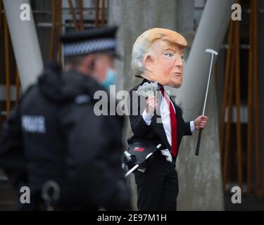 Édimbourg, Écosse, Royaume-Uni. 3 février 2021. Photo : avant un débat et un vote au Parlement écossais pour décider si le gouvernement écossais doit enquêter sur le financement par Donald Trump des terrains de golf écossais, les militants dépeigneront un faux Trump portant une tête géante, une cravate rouge et portant un panneau indiquant « Investigate Me! » En dehors du Parlement écossais. Il va également traîner son sac de golf débordant avec des billets de dollar. Crédit : Colin Fisher/Alay Live News Banque D'Images