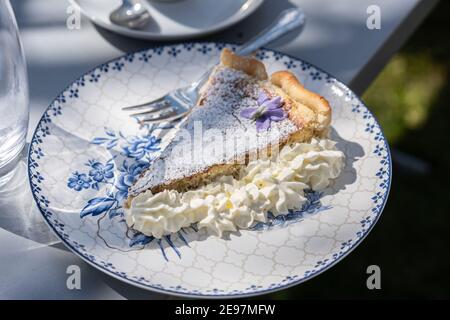 Tarte de pâques fraîche faite soi-même avec décoration de fleurs et café à l'extérieur. Banque D'Images