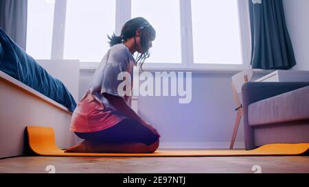 Jeune femme africaine s'exerçant sur le tapis de yoga dans sa chambre. Photo de haute qualité Banque D'Images