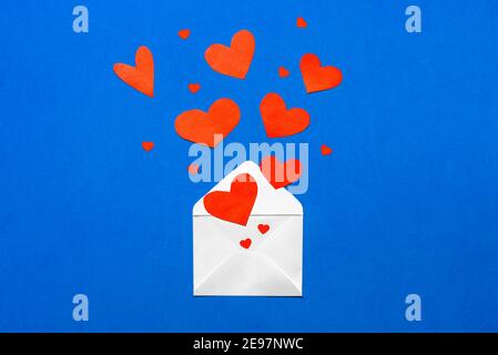 Enveloppe avec coeurs rouges sur fond bleu. Saint-Valentin Banque D'Images