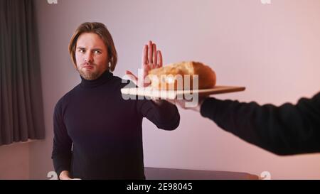 Jeune homme caucasien intolérant au gluten refusant de prendre du pain. Photo de haute qualité Banque D'Images