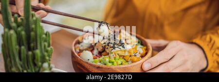 Homme mangeant le bol de poke biologique cru avec du riz et des légumes gros plan sur la table. Vue de dessus de la BANNIÈRE horizontale, FORMAT LONG Banque D'Images