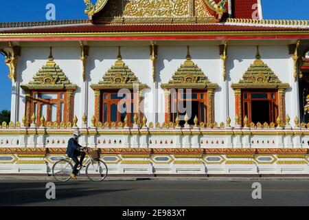 femme en train de faire du vélo devant un temple bouddhiste thaïlande Banque D'Images