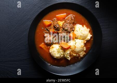 Concept alimentaire Spot Fosuc ragoût de bœuf classique maison avec purée pomme de terre dans un plat noir avec espace de copie Banque D'Images