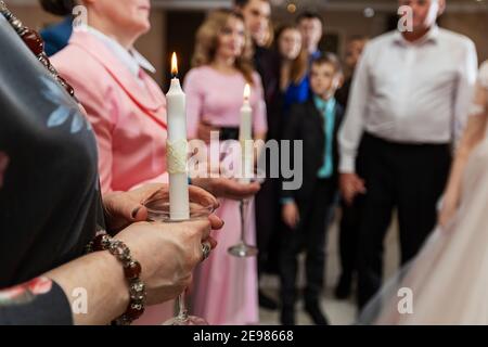 Une fille tient une bougie allumée dans ses mains, une tradition religieuse, un symbole de la foi chrétienne, une bougie de cire brûle avec une flamme égale Banque D'Images