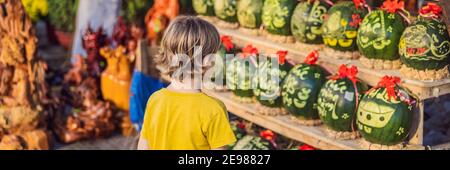 Un petit garçon visite les Watermelons avec une gravure festive sur Tet Eve. Tet est le nouvel an lunaire et célébré pendant quatre jours au Vietnam BANNIÈRE, LONG Banque D'Images