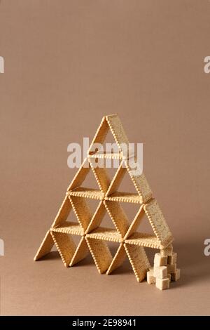 Encore une vie de composition créative avec biscuit carré équilibré en forme de triangle avec des morceaux de sucre brun. Banque D'Images