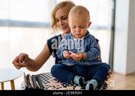 Bonne famille. Mère et bébé fille joue, embrassant, embrassant à la maison Banque D'Images