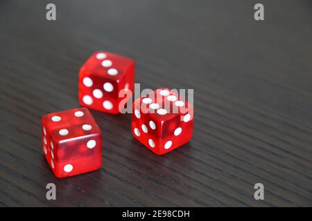 Dés rouges sur une table en bois sombre. Contexte pour les jeux de casino, les jeux de hasard, la chance ou le hasard Banque D'Images