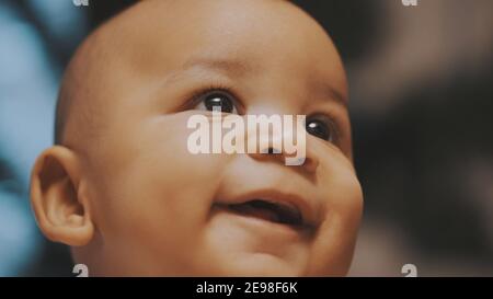 Portrait d'adorable curieux multiracial peau sombre bébé regardant vers le haut. . Photo de haute qualité Banque D'Images