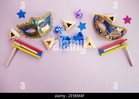 Fête de Purim. Hamantashen ou haman oreilles, le bruit et le masque sur fond gris. Vue de dessus Banque D'Images