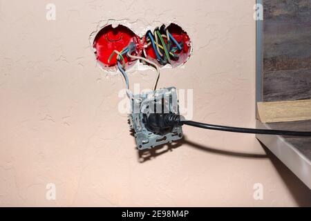 Prise électrique cassée lorsqu'elle est branchée à un appareil électrique. Risque de court-circuit et d'incendie. Utilisation incorrecte des appareils. Banque D'Images