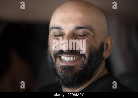 Portrait rapproché d'un homme à tête blanche barbu avec de belles dents blanches sourire aux yeux fermés Banque D'Images