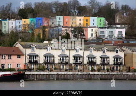 Vue sur la rivière Avon à Bristol, Angleterre, vers des appartements modernes au bord de la rivière, et des maisons anciennes et colorées en terrasse derrière. Banque D'Images