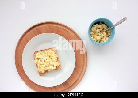 Sandwich à la salade d'œufs avec du pain grillé au blé entier et des micro-légumes sur plaque sur fond blanc. Concept d'alimentation saine Banque D'Images