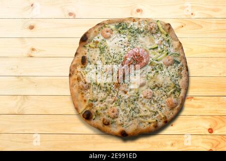 pizza avec crevettes et courgettes et fromage sur fond de bois dans la vue de dessus plat, espace de copie Banque D'Images