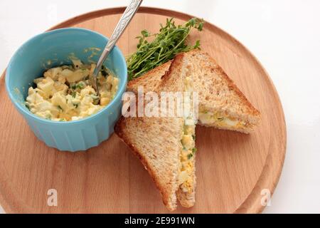 Sandwich à la salade d'œufs avec du pain grillé au blé entier et des micro-légumes sur plaque sur fond blanc. Concept d'alimentation saine Banque D'Images