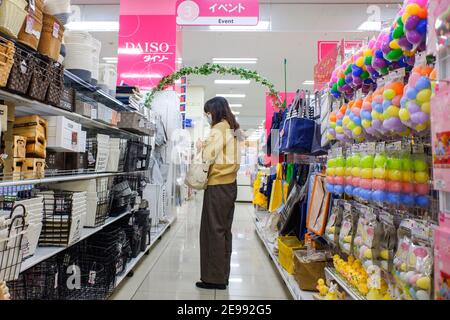 Une femme portant un masque facial comme mesure préventive contre la propagation des magasins du coronavirus (COVID-19) au magasin Diso 100 Yen à Tokyo. Diso est l'une des plus grandes chaînes de magasins de 100 yens au Japon avec une gamme de plus de 100,000 articles allant de l'équipement de jardin aux chargeurs de téléphone pour 100 yens (env USD 1.00). Masques faciaux, usine de Diso Japan en chine fabrique 2 millions de masques chirurgicaux tous les jours, masques pour enfants sont également disponibles. Banque D'Images