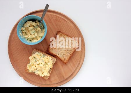 Sandwich à la salade d'œufs avec du pain grillé au blé entier et des micro-légumes sur plaque sur fond blanc. Concept d'alimentation saine Banque D'Images