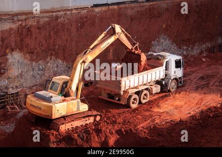 BRASILIA, BRÉSIL - 6 JUIN 2015 : benne basculante de chargement de pelle hydraulique sur le site de construction d'un nouveau bâtiment commercial. Banque D'Images