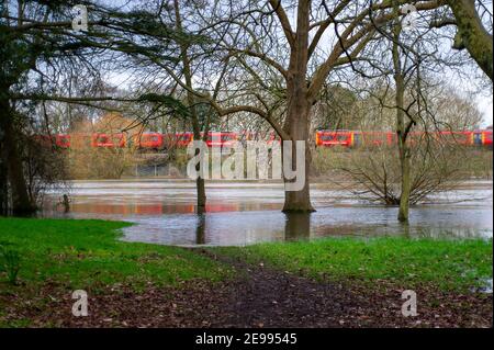 Eton, Windsor, Berkshire, Royaume-Uni. 3 février 2021. Un train à destination de Waterloo passe par les terrains de jeu inondés du Eton College. Une alerte d'inondation demeure en place le long de la Tamise, de Maidenhead à Windsor et Eton. On s'attend à ce que les niveaux des cours d'eau demeurent élevés pendant les prochains jours, mais on ne s'attend pas actuellement à des inondations. Crédit : Maureen McLean/Alay Live News Banque D'Images