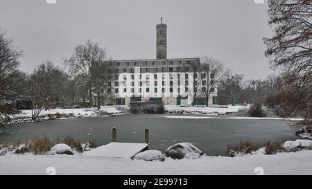 Brunswick, Allemagne. 02 février 2021. Vue sur un étang gelé dans le parc de Kiryat Tivon, en arrière-plan, un hôtel se trouve en face de la tour de pression d'une rivière des travaux d'eau sur l'Oker, connue sous le nom de « tour d'eau ». Credit: Stefan Jaitner/dpa/Alay Live News Banque D'Images