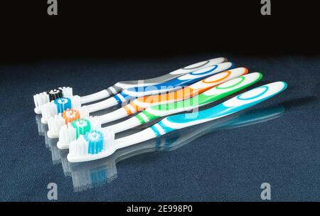 Jeu de brosses à dents sur table en verre avec instruments Reflection pour l'hygiène sur fond noir Banque D'Images