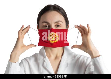 Respirateur avec drapeau du Kirghizistan le docteur met sur le masque médical isolé sur fond blanc. Banque D'Images